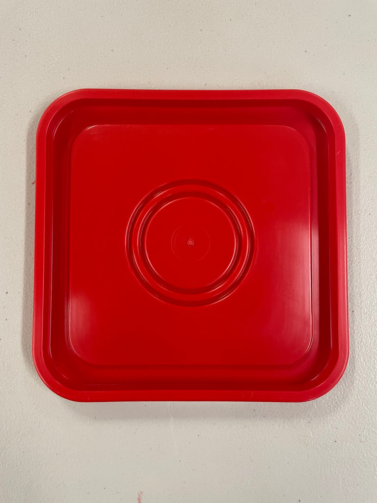 A RentACoopUS red plastic tray on a white surface.